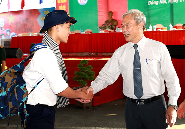 Secretary Nguyen Phu Cuong of the provincial Party Committee presents flowers to recruits who are about to depart to begin their military service.