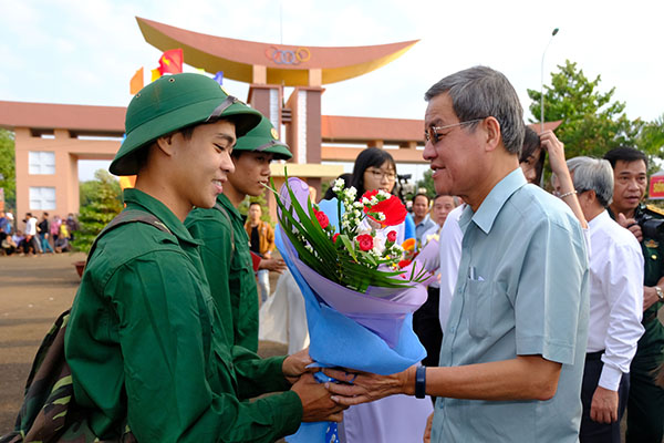 Vice Chairman Tran Van Vinh of Dong Nai provincial People's Committee presents flowers to new soldiers in Long Thanh district.