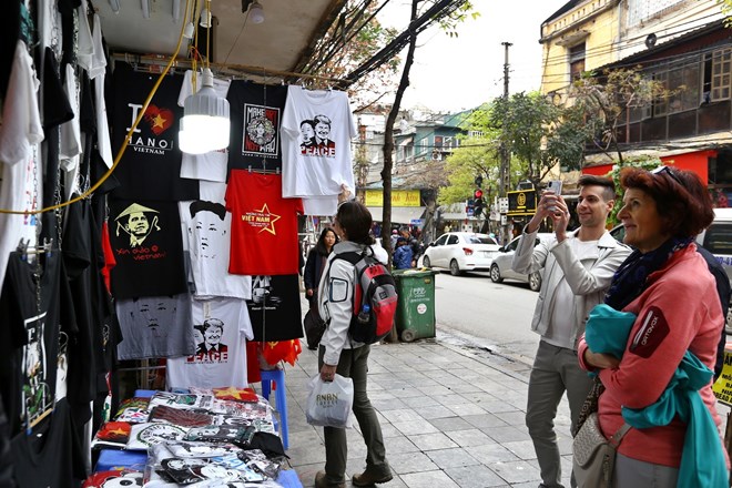 Foreign tourists visit a shop selling souvenirs of the second summit between the US and the Democratic People's Republic of Korea in Hanoi on February 27 and 28