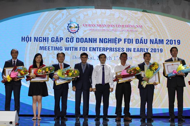 Authorities of Dong Nai present merit certificates to FDI firms with outstanding business performance at the meeting on March 1 (Photo: VNA)