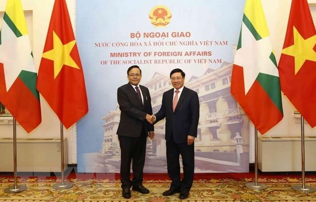 Vietnamese Deputy Prime Minister and Foreign Minister Pham Binh Minh (R) shakes hands with Myanmar Minister of International Cooperation U Kyaw Tin before the meeting in Hanoi on March 12 