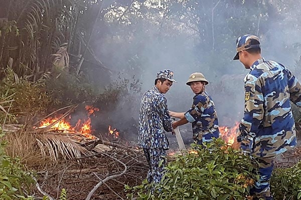 Cán bộ, chiến sĩ Căn cứ 696 (Vùng 2 Hải quân) giúp dân dập tắt đám cháy ngày 26-3. Ảnh: Đình Thảo.