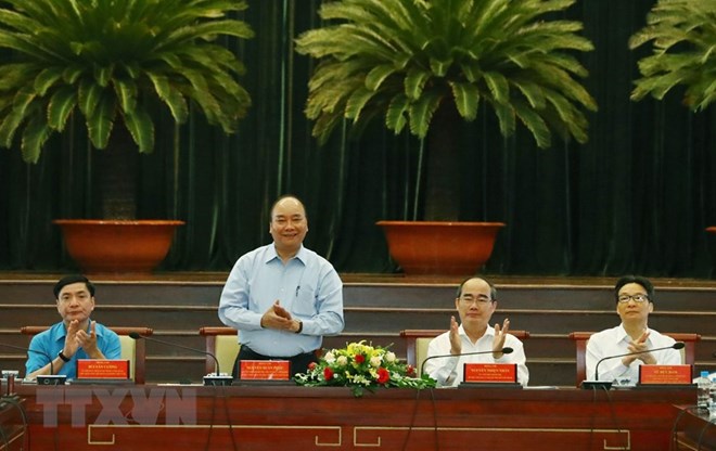 PM Nguyen Xuan Phuc (standing) at the meeting with highly-skilled workers in HCM City. (Photo: VNA)