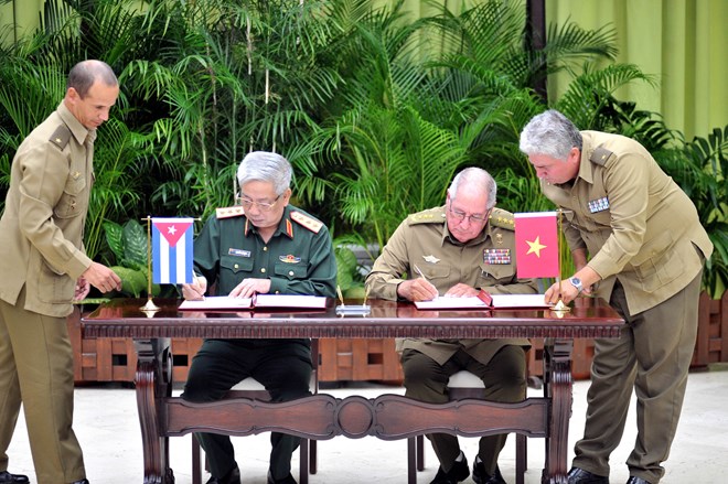 Deputy Minister of Defence Sen. Lt. Gen. Nguyen Chi Vinh and Minister of Revolutionary Armed Forces Sen. Lt. Gen. Leopoldo Cintra Frias sign minutes on implementing a dossier on the 60-year history of Vietnam-Cuba 60-year defence partnership.