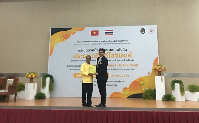 Rector of the Lampang Rajabhat University Somkiat Saityhanoo (L) presents the book to a representative of the Thai Foreign Ministry at a ceremony on May 22 (Photo: VNA)