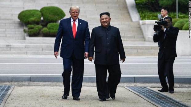 Tổng thống Mỹ Donald Trump và Nhà lãnh đạo Triều Tiên Kim Jong-un tươi cười bước chân trên lãnh thổ Triều Tiên ở DMZ. (Nguồn: Getty Images)