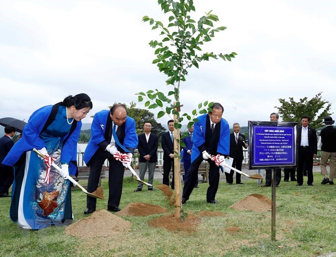 Prime Minister Nguyen Xuan Phuc (second from left), his spouse and Toshihiro Nikai, plant a tree to mark the special event.