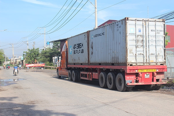 Xe container  vận chuyển hàng hóa  không phải của doanh nghiệp khai thác đá bị chặn lưu thông trên đường Đinh Quang Ân do người dân dựng hàng rào chặn xe tải ben chở vật liệu đá xây dựng từ các mỏ đá Tân Cang. Ảnh: D.LINH