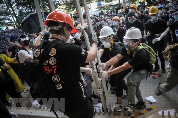 Những người biểu tình quá khích phá hàng rào để tràn vào tòa nhà cơ quan lập pháp ở Hong Kong, Trung Quốc, ngày 1-7. (Ảnh: AFP/TTXVN)