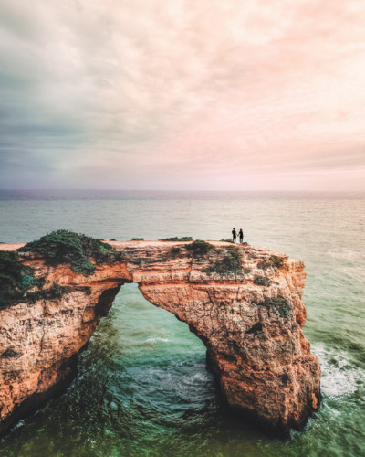   Portugal provided the setting for this inspiring picture, which shows a couple holding hands as they stand on rocks over the sea.