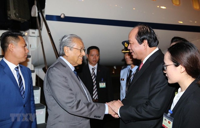 Malaysian Prime Minister Mahathir Mohamad (second from left) is welcomed at Noi Bai International Airport. 