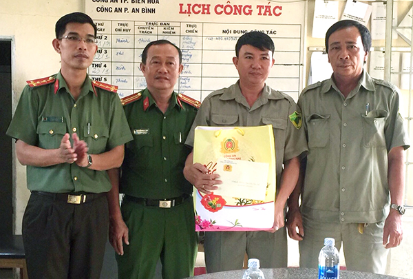 Đại úy Huỳnh Văn Tấn Đông (bìa trái), Phó trưởng phòng Xây dựng phong trào bảo vệ an ninh Tổ quốc Công an tỉnh tặng quà cho các tập thể, cá nhân có thành tích xuất sắc trong công tác đấu tranh phòng chống tội phạm