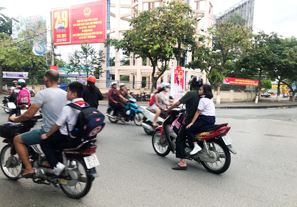 Nhiều phụ huynh Trường tiểu học Trịnh Hoài Đức (TP.Biên Hòa) không cho con đội mũ bảo hiểm khi tham gia giao thông. Ảnh: K.Liễu