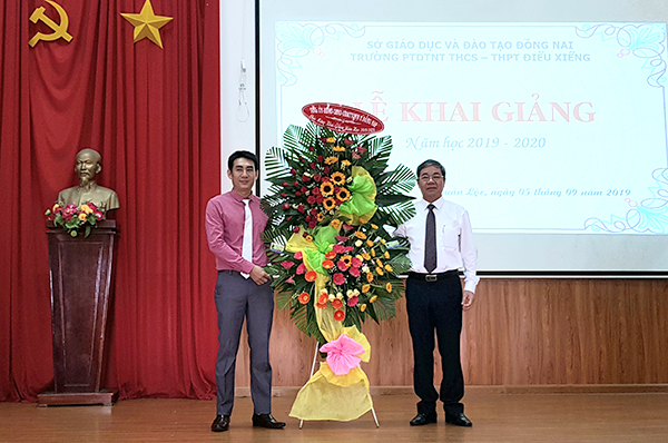 Phó chủ tịch UBND tỉnh Nguyễn Quốc Hùng tặng hoa chúc mừng năm học mới cho đại diện Trường PTDTNT THCS-THPT Điểu Xiểng. 