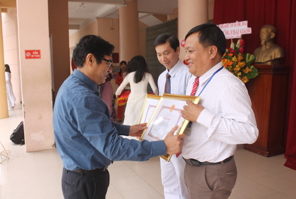 Ông Nguyễn Sơn Hùng trao bằng khen của UBND tỉnh cho 2 giáo viên có nhiều thành tích trong công tác quản lý và giảng dạy
