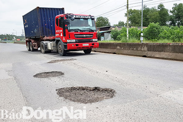 Một đoạn trên tuyến đường vào Khu công nghiệp Long Đức xuất hiện nhiều ổ voi, ổ gà và dặm vá dày đặc. Ảnh: V. Thế