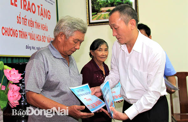 Ông Nguyễn Trọng Hậu, Phó tổng biên tập Báo điện tử Đảng Cộng Sản Việt Nam trao tặng sổ tiết kiệm cho người có công ở huyện Trảng Bom. (ảnh: Văn Truyên)