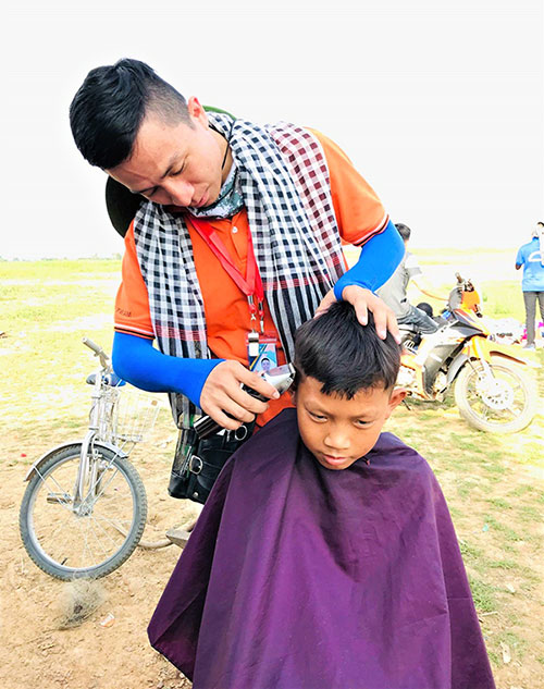Đoàn viên thanh niên tình nguyện Trường đại học Lạc Hồng cắt tóc miễn phí cho trẻ em làng bè khu vựcxã Mã Đà (huyện Vĩnh Cửu)