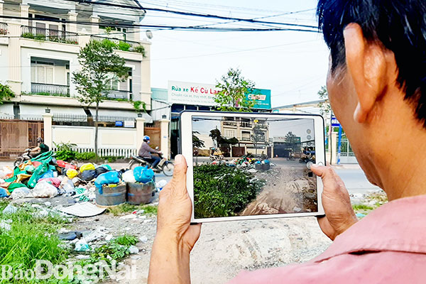 Người dân phường Hiệp Hòa (TP.Biên Hòa) chụp hình phản ảnh tình trạng rác trước lối vào khu dân cư thông qua ứng dụng “Biên Hòa trực tuyến