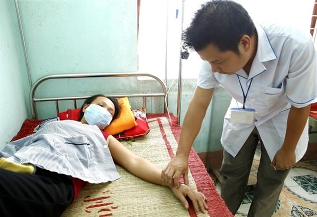 A doctor examines a woman with dengue fever at Quang Phuong communal health station in the central province of Quang Binh’s Quang Trach district.