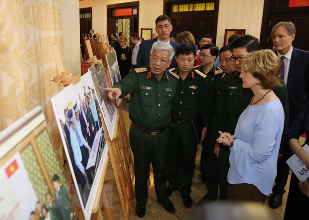 Thượng tướng Nguyễn Chí Vịnh và bà Bonnie Glick xem trưng bày ảnh về một số hoạt động giữa Việt Nam và Hoa Kỳ trong việc xử lý ô nhiễm dioxin tại Việt Nam. (Ảnh: Dương Giang/TTXVN)
