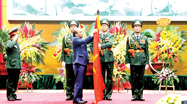 Thủ tướng Nguyễn Xuân Phúc, Chủ tịch Hội đồng Thi đua - khen thưởng Trung ương gắn Huân chương Lao động hạng Nhất lên lá cờ truyền thống của Hội Cựu chiến binh Việt Nam
