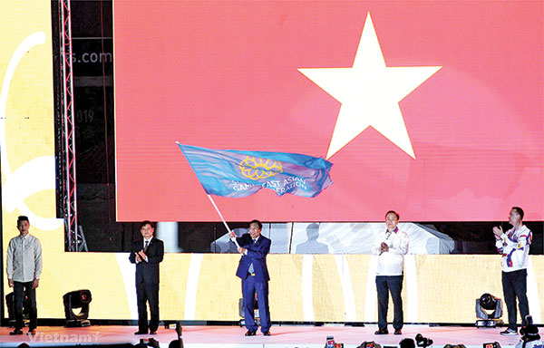 Bộ trưởng Bộ Văn hóa - thể thao và du lịch Nguyễn Ngọc Thiện tiếp nhận cờ đăng cai SEA Games 31. Ảnh: Vietnam+