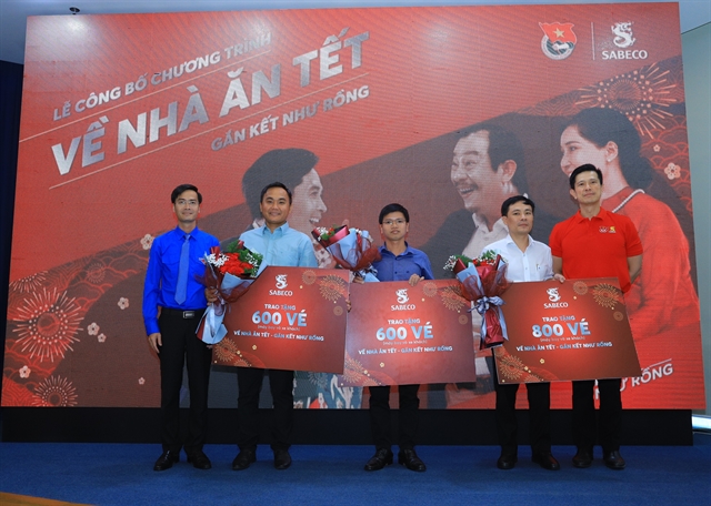 Bennett Neo (right), general director of Sabeco, deliver free flight and bus tickets meant for workers to representatives of industrial and processing zones in HCM City, Bình Dương and Đồng Nai provinces. — Photo courtesy of Sabeco  Read more at http://vietnamnews.vn/economy/569770/tet-spirit-sabeco-gifts-air-bus-tickets-to-2000-outstanding-workers.html#BGyukRdRvpU39QYb.99