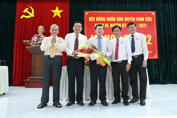 Hình ảnh ông Phạm Minh Phước( người ở giữa cầm hoa) được bầu làm Chủ tịch UBND huyện Vĩnh Cửu nhiệm kỳ (2016 - 2021)