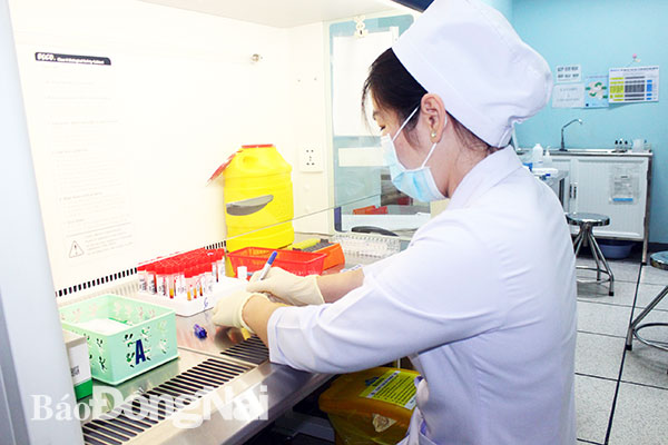 Kỹ thuật viên Khoa Huyết học Bệnh viện đa khoa Đồng Nai thực hiện quy trình xét nghiệm máu phát hiện HIV. Ảnh: H.Dung