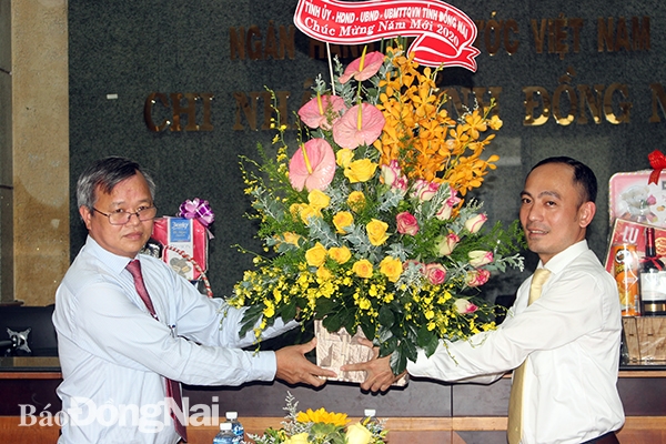 Chairman Đinh Quoc Thai presents flowers to Dofico's representative.