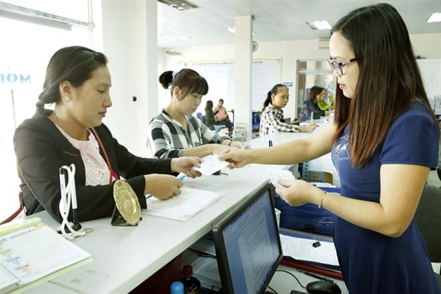 A worker of Phu Tho Social Insurance Agency talks to a social-insurance user in northern Phu Tho Province. (Photo: VNA)