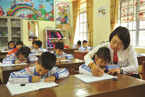 Nguyen Thi Hang, an outstanding teacher of the Muong ethnic minority group, guides her students how to improve their handwriting__Photo: Minh Duc/VNA