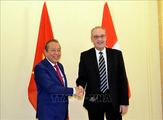 Permanent Deputy Prime Minister Truong Hoa Binh (L) and Vice President and head of the Department of Economic Affairs, Education and Research of Switzerland Guy Parmelin 