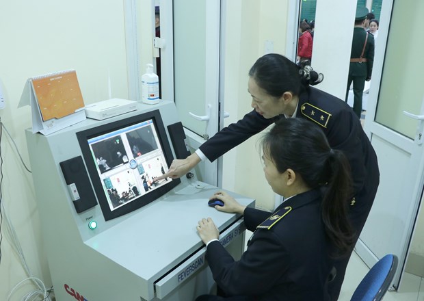 Staff of the international health quarantine centre of Quang Ninh province examine the body temperature of people from China via a thermal scanner at Mong Cai Border Gate (Photo: VNA)