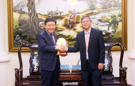 Chairman Cao Tien Dung (R) presents souvenir gift to