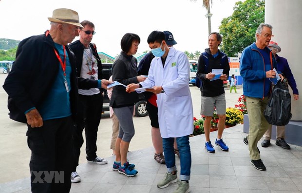 A health worker is delivering leaflets on nCoV to visitors to Ha Long Bay, Quang Ninh province. (Photo: VNA)