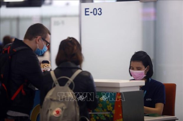 Workers and passengers wear face masks at an airport in Vietnam.