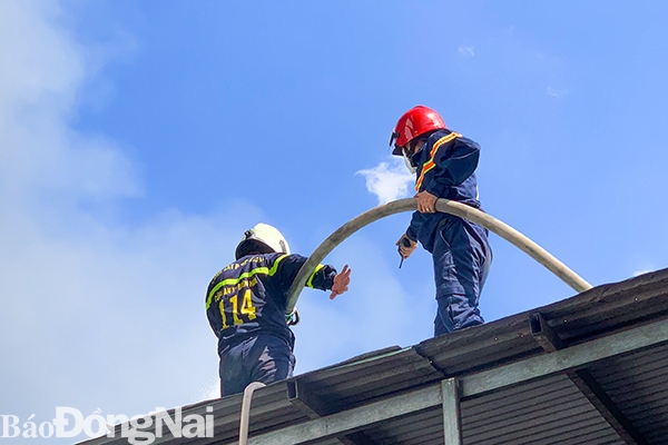  Lực lượng chữa cháy tiếp cận ngọn lửa bằng cách leo lên trên nóc nhà các hộ dân