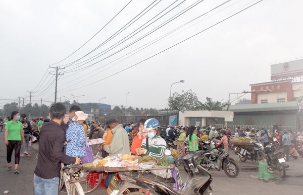 Công nhân lao động mua đồ ăn sáng trước cổng công ty tại Khu công nghiệp Bàu Xéo (H.Trảng Bom). Nhiều hàng rong không được che đậy cẩn thận, tiềm ẩn nguy cơ mất vệ sinh cao