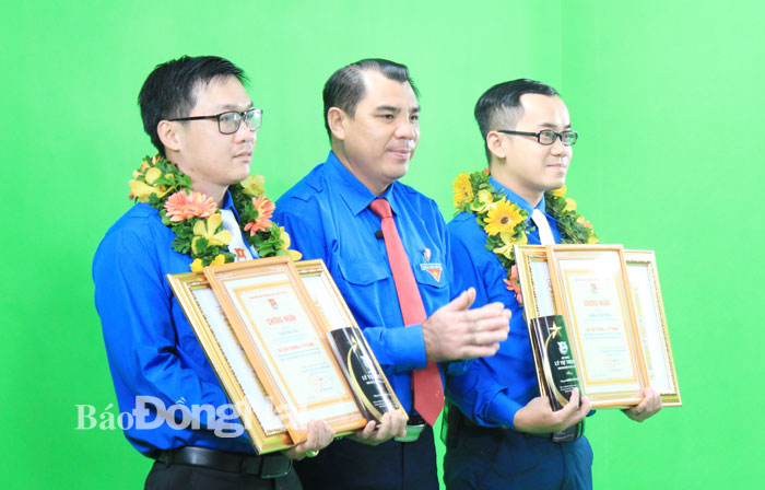 Bí thư Tỉnh đoàn Nguyễn Cao Cường (giữa) trao giải thưởng Lý Tự Trọng của Trung ương Đoàn cho 2 cán bộ Đoàn tiêu biểu  tại phim trường Trường đại học Lạc Hồng