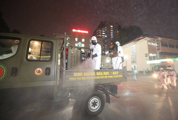 Soldiers fumigate Bach Mai Hospital in Hanoi on late March 28 after several COVID-19 cases had been found here (Photo: VNA)