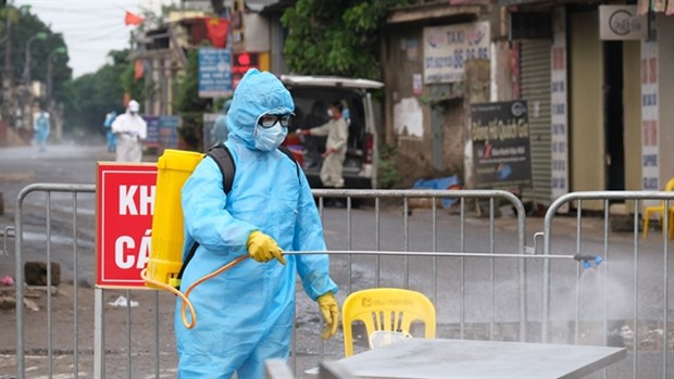 A medical worker sprays disinfectant in Ha Loi village, Me Linh district, Hanoi, after a resident tested positive for COVID-19. (Photo: VNA)