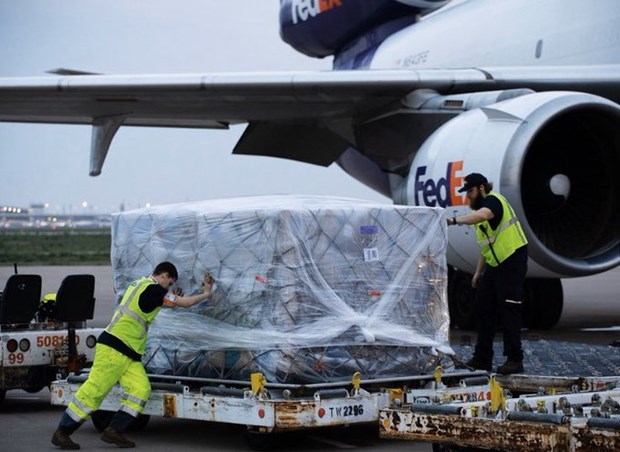 FedEx workers load the protective suits onto a plane for shipment to the US.