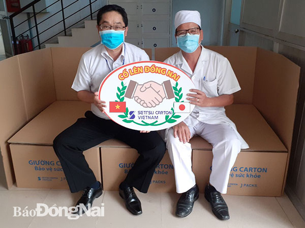 Đại diện Công ty TNHH Settsu Carton Việt Nam (trái) trao tặng giường và biểu tượng khích lệ trong cuộc chiến chống Covid-19 cho lãnh đạo Bệnh viện Phổi Đồng Nai