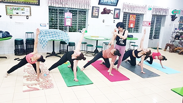 Chị Phạm Thị Bích Liễu hướng dẫn các thành viên trong gia đình tập yoga nâng cao sức khỏe