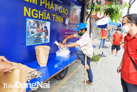 Người dân đến nhận gạo tại “ATM gạo” lưu động trên đường Phạm Văn Thuận (TP.Biên Hòa)