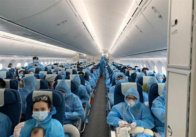 Vietnamese citizens wear protective suits during a repatriation flight from the UK on June 4. Dong Nai Province received and quarantined 321 of them – PHOTO: VNA