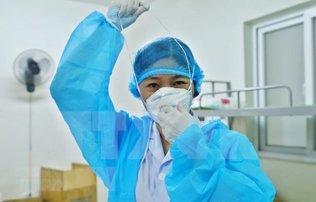 A doctor puts on protective gear before entering a hospital room for COVID-19 patients (Photo: VNA)