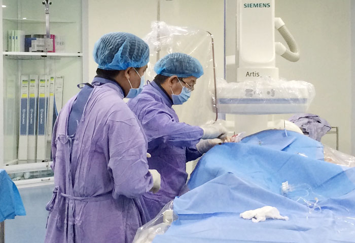 BS CKI Phạm Quang Huy, Trung tâm Tim mạch can thiệp Bệnh viện Đa khoa Thống Nhất cùng cộng sự thực hiện một ca đặt stent cho bệnh nhân bị tắc nghẽn mạch vành